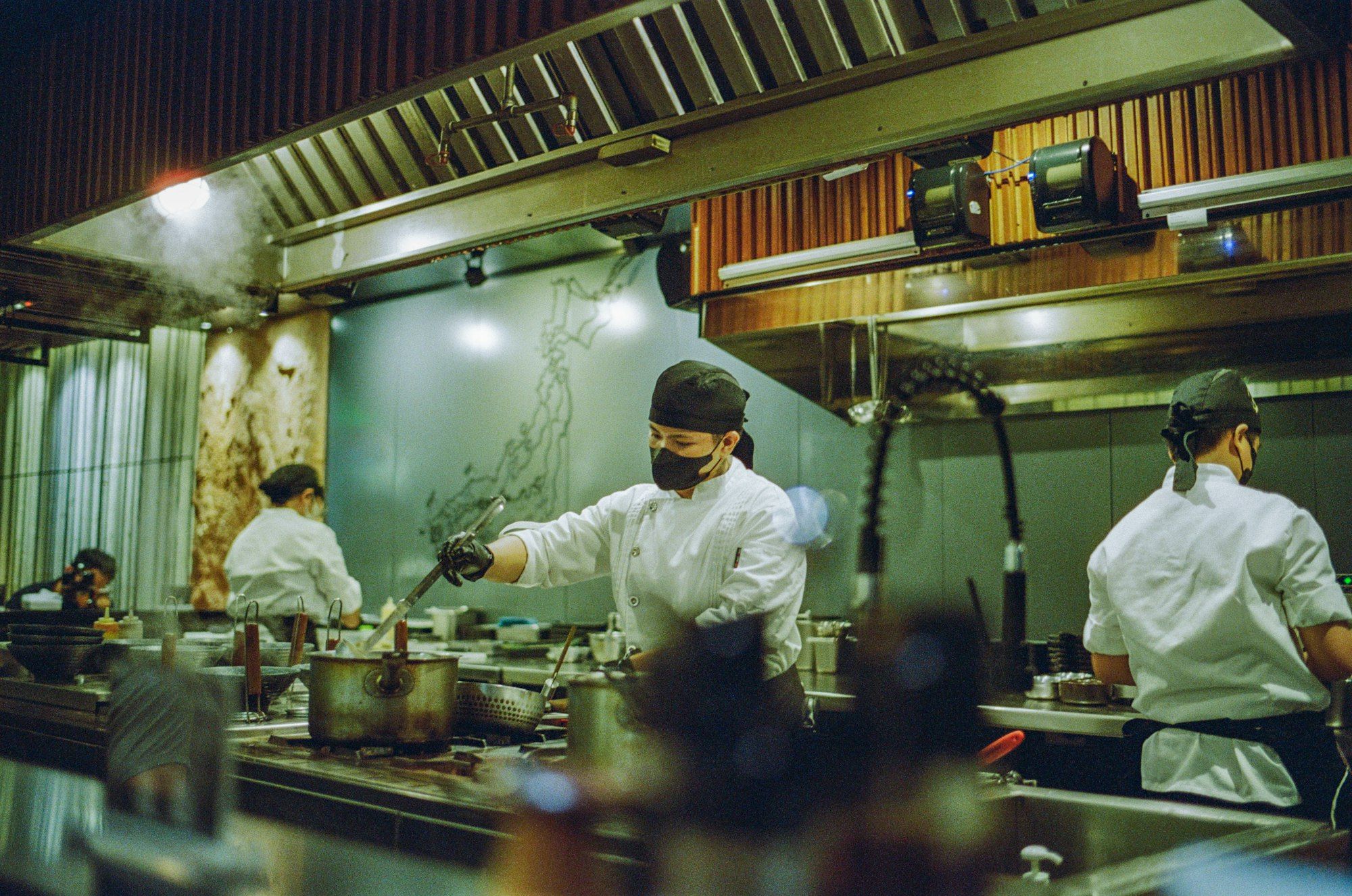 A team of chefs preparing food during service in a busy restaurant kitchen