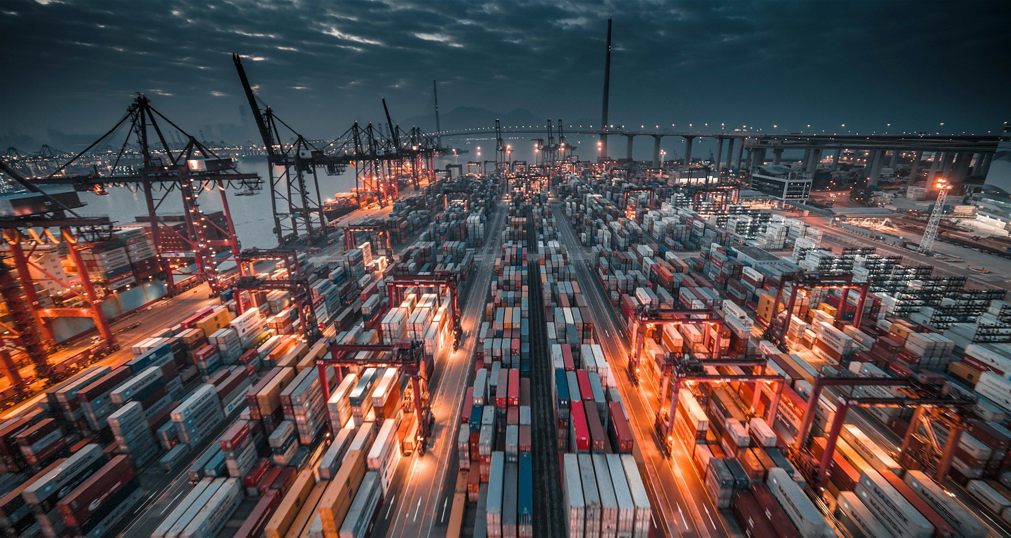 Stacked shipping containers and cranes at a working port
