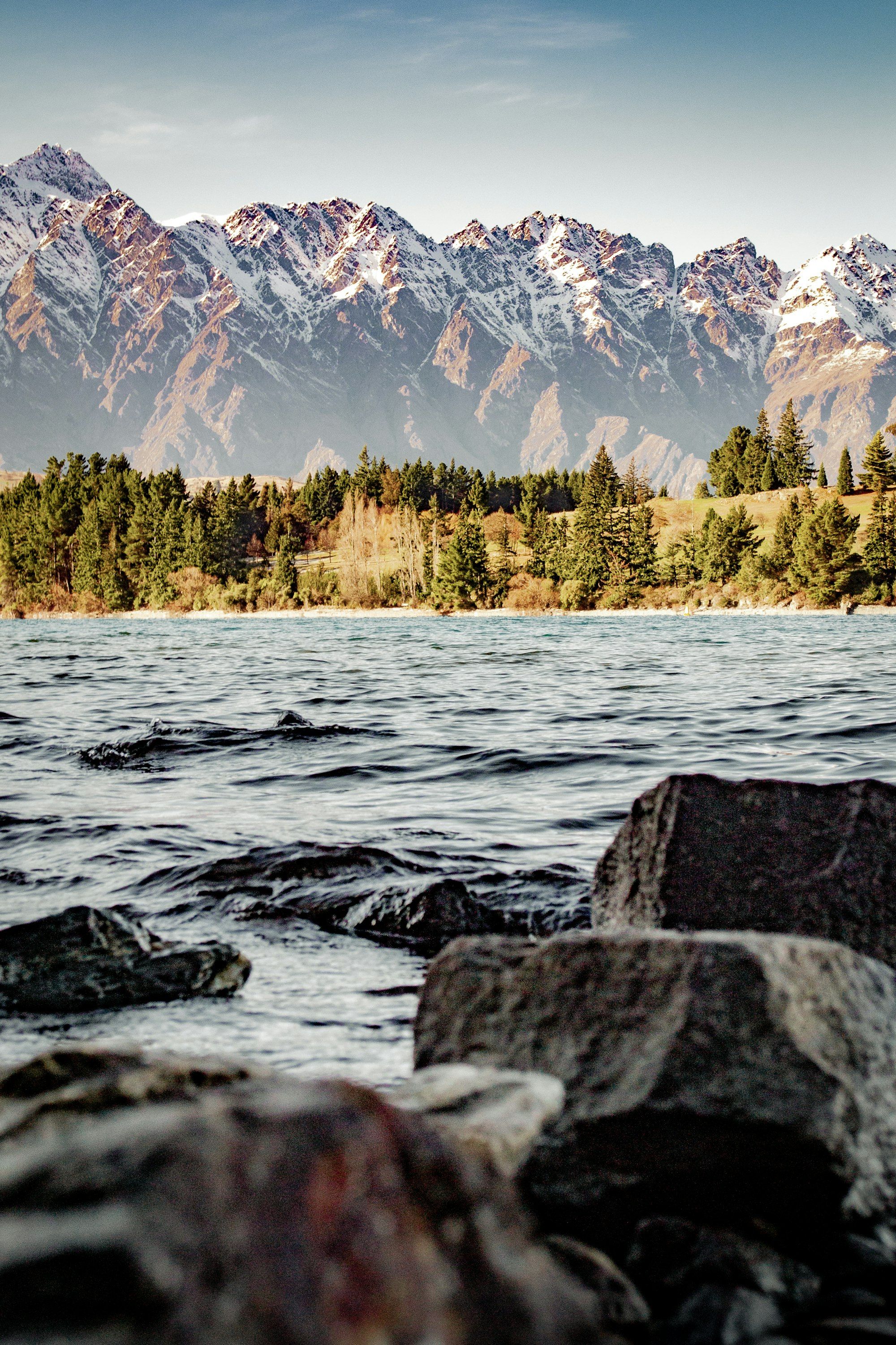 Snow-covered mountains above green trees near Queenstown in winter